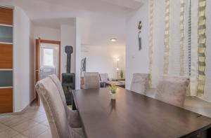 een eetkamer met een houten tafel en stoelen bij Apartment Šop in Čižići