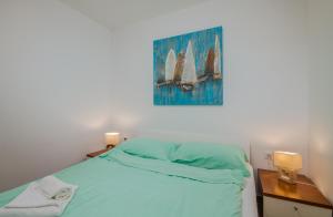 een slaapkamer met een bed en een schilderij aan de muur bij Apartment Šop in Čižići