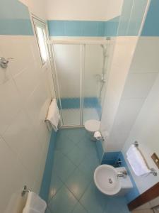 ein Bad mit einer Dusche, einem WC und einem Waschbecken in der Unterkunft Hotel Merano in Grado