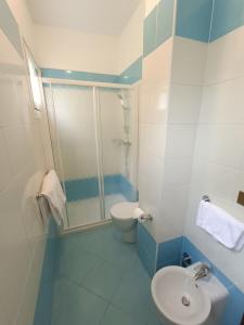 ein Bad mit einer Dusche, einem WC und einem Waschbecken in der Unterkunft Hotel Merano in Grado