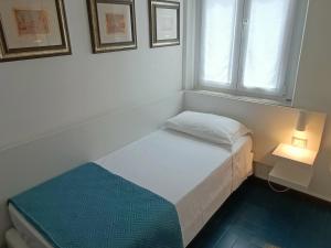 ein kleines Bett in einem Zimmer mit Fenster in der Unterkunft Hotel Merano in Grado