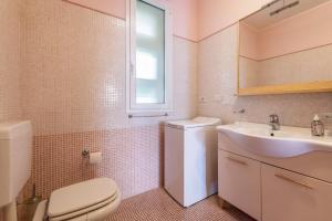 a bathroom with a white toilet and a sink at Appartamento Gardazzurro in Padenghe sul Garda +23 photos