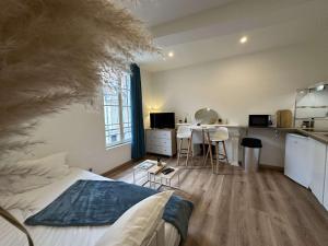 a bedroom with a bed and a kitchen with a table at Le Blue- hyper centre ville in Sens