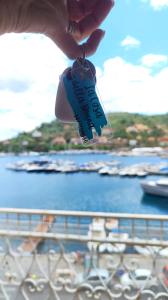 osoba trzymająca breloczek z widokiem na wodę w obiekcie Casa della Nonna casevacanzeargentario w mieście Porto Santo Stefano