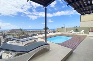 a swimming pool with lounge chairs and a swimming pool at Harmony - Beach & Dream rentals in Playa de las Americas