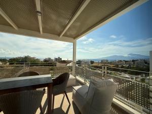 卡拉馬基的住宿－Ammokrinos Luxury Homes,150m from the beach，设有一个配有桌椅并享有美景的阳台。