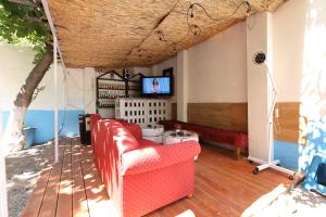 a porch with a couch and a tv on a deck at Hostel Osho in Tirana