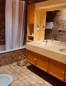 La salle de bains est pourvue d'un lavabo et d'un miroir. dans l'établissement Piazza Ascona Hotel & Restaurants, à Ascona