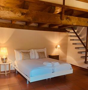 Schlafzimmer mit einem weißen Bett und Holzdecken in der Unterkunft Piazza Ascona Hotel & Restaurants in Ascona