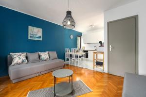a living room with a couch and a blue wall at Blue Apartment in Vrsar