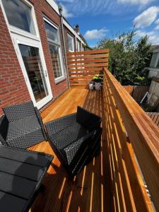 een houten bank met twee stoelen op een terras bij Da Costa 12A in Leiden
