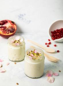 two mason jars of pomegranate overnight oats on a white table at Aegean Palace in Plaka