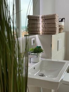 a bathroom with a sink and a stack of towels at Rheinblick-Oase Oppenheim in Oppenheim +43 photos