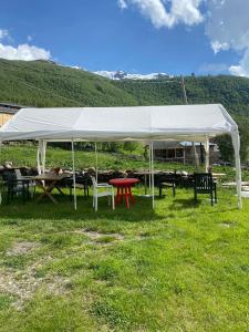 a white tent with tables and chairs in a field at Old Tower Guesthouse Ushguli in Ushguli