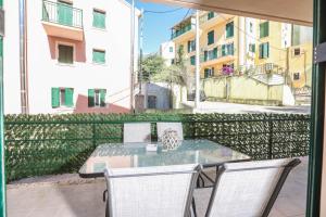 Un patio con una mesa y sillas en un balcón. en Breezy Dream, Corfu, en Corfú