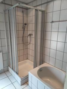a bathroom with a shower and a bath tub at Gästehaus Windheim (Büchig) in Stutensee