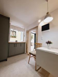 a kitchen and living room with a table and a chair at Casa Myrilla in Corfu