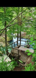 a wooden picnic table sitting next to a river at Shkodra Guest House in Shkodër