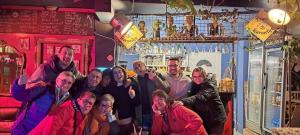 Un gruppo di persone che posano per una foto in un bar di Divina Hostel a Tirana