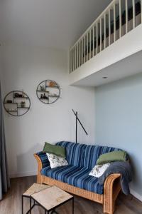 un salon avec un canapé bleu et un escalier dans l'établissement Pronkhuisje, à Oterleek