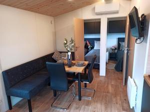 salon ze stołem i kanapą oraz sypialnia w obiekcie Tiny Haus 5 w mieście Nabburg