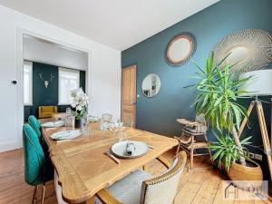 a dining room with a wooden table and chairs at Élégance Malouine - 500m Plage in Dunkerque