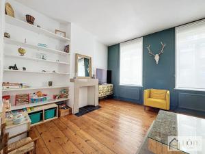 a living room with white shelves and a yellow chair at Élégance Malouine - 500m Plage in Dunkerque