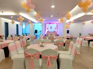 um salão de banquetes com mesas e balões cor-de-rosa e brancos em Mavens White Artemis Hospital Road Sector 52 Gurgaon em Gurgaon