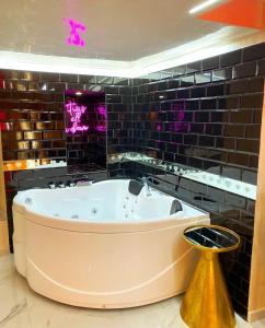 Lovely homes في جينوا: حوض استحمام كبير في حمام مع أضواء أرجوانية