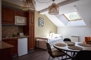 a kitchen and a room with a table and a bed at Apartamentos San Jorge in Nueva de Llanes