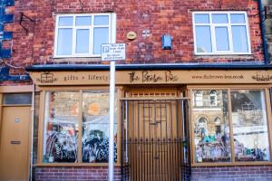a store front of a brick building with a sign in front at The Brown Box Holiday Let in Loftus