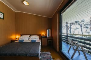 a bedroom with a bed and a balcony with a window at Kastytis in Nida