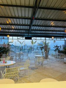 Mojo M Villa -Airport Boutique Hotel في جايبور: فناء به طاولات وكراسي يطل على الماء