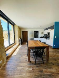 una sala da pranzo con tavolo in legno e una cucina di Maison"Charme"Piscine"Domme a Domme