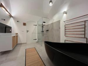 a bathroom with a black bath tub and a sink at L'Arco Trieste studio living 1 in Trieste +12 photos