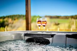 HargartenRelax Lodge (Eifel)的浴缸顶部坐两杯葡萄酒