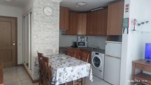 a kitchen with a table and a kitchen with a laundry room at Casa Jardins da Rocha in Portimão
