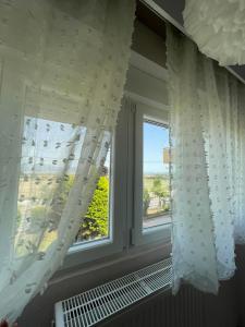 a window with white curtains and a view of the ocean at La Famiglia Appartment in Perea