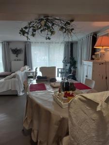 ein Wohnzimmer mit einem Tisch und einem weißen Tischtuch in der Unterkunft Gîte EMOZIONE in Guebwiller