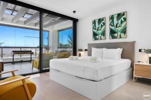 Un dormitorio con una cama blanca y una sala de estar. en ViVi Homes -Villa Yara Pool, Sauna, Spa & Garden, en Mijas