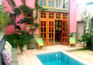 a pink house with a swimming pool and two chairs at Secret Cottage Granada Nicaragua in Granada