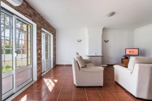 un soggiorno con mobili bianchi e un muro di mattoni di GuestReady - Peaceful Escape in Praia de Mira a Praia de Mira