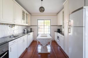 una cucina con armadi bianchi e un tavolo di GuestReady - Peaceful Escape in Praia de Mira a Praia de Mira