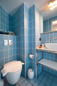 a blue tiled bathroom with a toilet and a sink at Cretan Loft in Platanias +28 photos