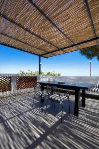 a ping pong table and two chairs under a pergola at Cretan Loft in Platanias