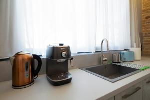a coffee maker on a counter next to a sink at Cretan Loft in Platanias