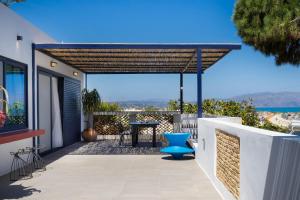 a pergola on a balcony with a table and a blue chair at Cretan Loft in Platanias