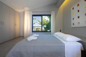a white bedroom with a large bed with white pillows at Cretan Loft in Platanias