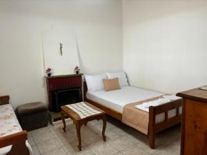 a small bedroom with a bed and a fireplace at Georgaras Accommodation in Platanoússa