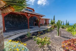 ein Haus mit einem Garten mit Blumen davor in der Unterkunft Apartamento Hibisco: Jacuzzi y Vistas al Atlántico in Adeje